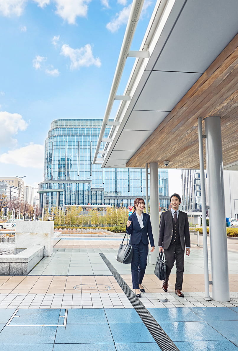 金沢駅を歩く男女の社員