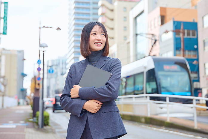 ファイルを抱えて微笑む女性社員
