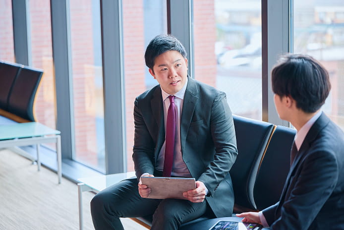 ロビーで会話をする男性社員